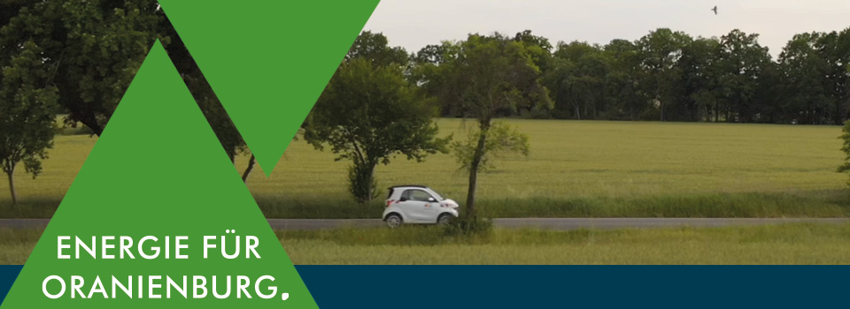 Grafik mit gr&uuml;nem Dreieck und dem Claim &sbquo;Energie f&uuml;r Oranienburg. &lsquo; vor einem E-Auto das eine Landstra&szlig;e langf&auml;hrt.